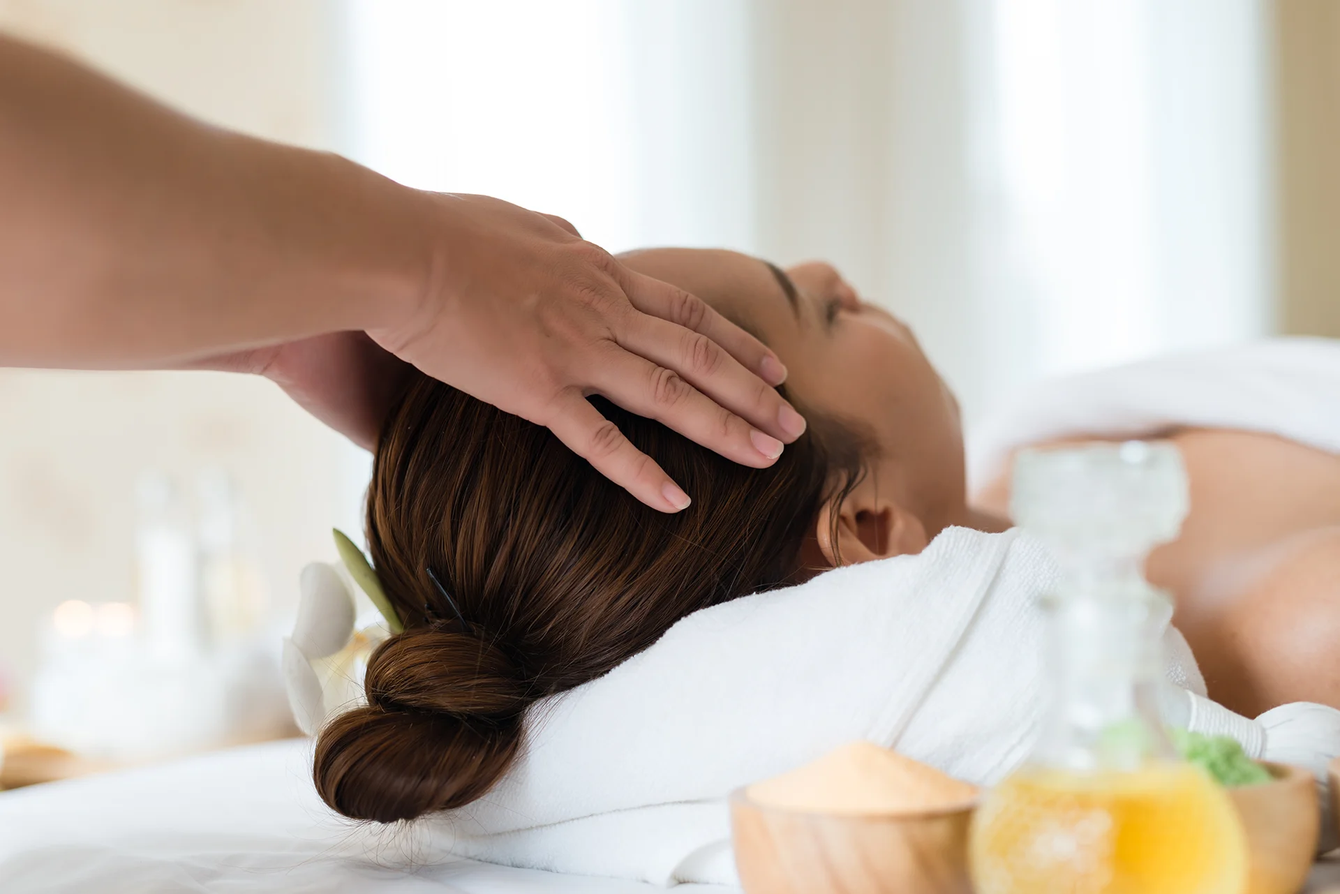 Mujer en sesión de spa, recibiendo masaje en la cabeza
